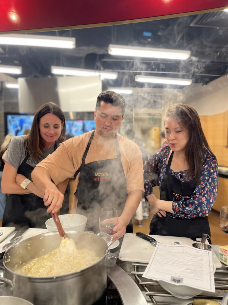 Three people smiling while mixing batter