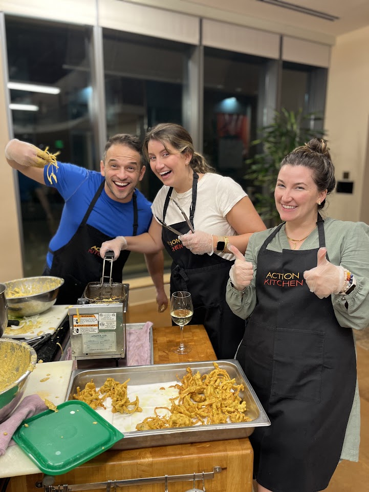 People happily posing while preparing fried calamari