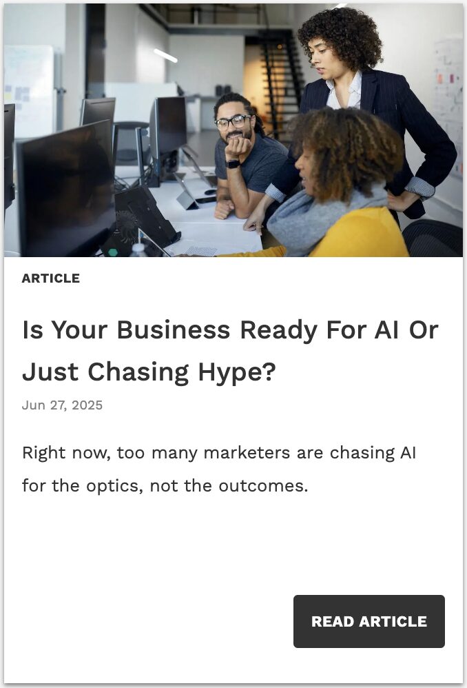 Team of professionals in a modern office collaborating around a computer, reflecting on AI strategy decisions — linking to Forbes article by Tod Loofbourrow called 'Is Your Business Ready For AI Or Just Chasing Hype?